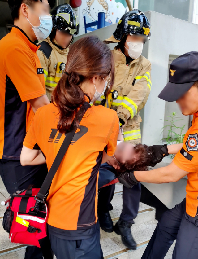 지난 5일부터 엘리베이터 운행이 중단된 인천시 중구 항동7가의 한 아파트 단지에서 12일 응급환자가 계단을 통해 병원으로 옮겨지고 있다. 연합뉴스