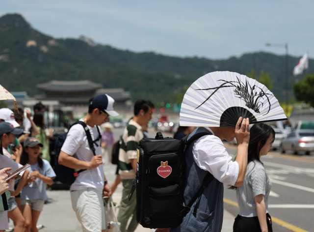 무더위가 이어진 17일 서울 광화문광장에서 한 시민이 부채로 햇볕을 가리고 있다. 연합뉴스