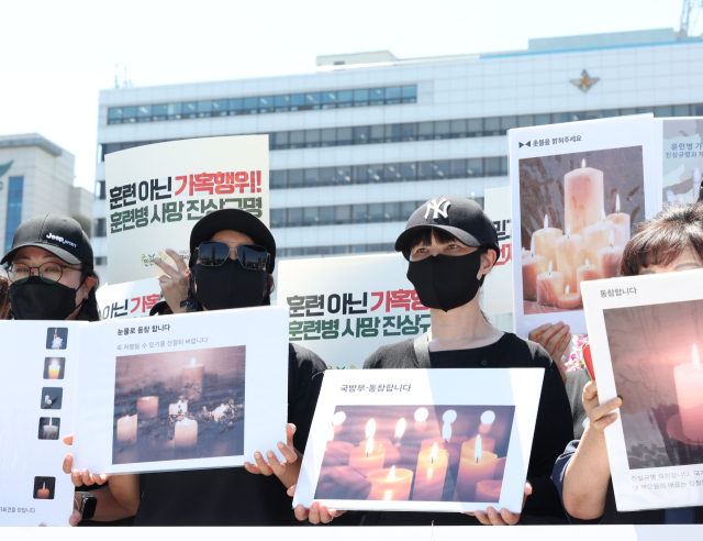 4일 서울 용산구 국방부 앞에서 열린 육군 12사단 훈련병 가혹행위 사망사건 규탄 및 진상규명 촉구 기자회견에서 현·전역 병사 부모들과 군인권센터 관계자들이 손팻말을 들고 있다.연합뉴스