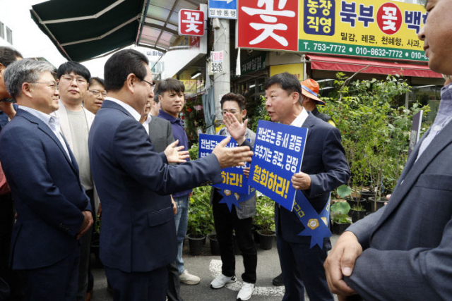 정병회 순천시의회 의장과 시의원들이 지난 5월 30일 순천 웃장을 방문한 김영록 도지사를 만나 의대 공모 중단을 요구하고 있다. 사진 제공=순천시의회