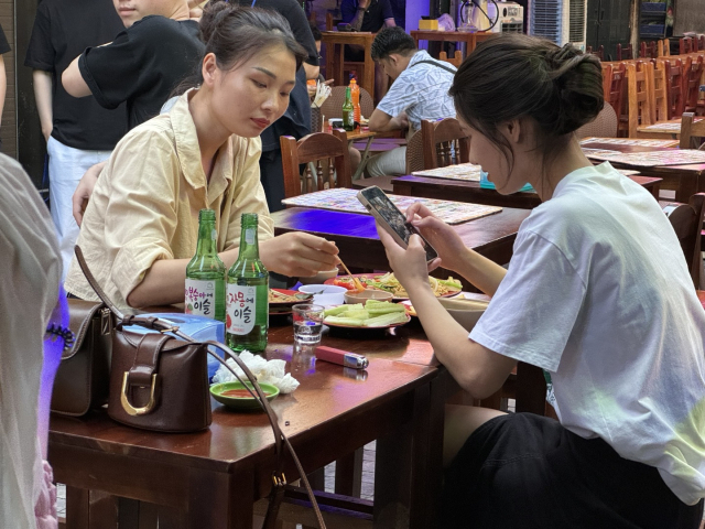 지난 10일(현지 시간) 베트남 하노이 타히엔 거리에서 현지 소비자들이 하이트진로 소주를 마시고 있다. 황동건 기자