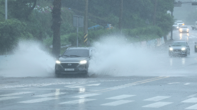 제주도에 호우특보가 내려진 20일 제주 서귀포시 중문의 한 도로에 빗물이 고여 차량이 물보라를 일으키며 지나고 있다. 연합뉴스