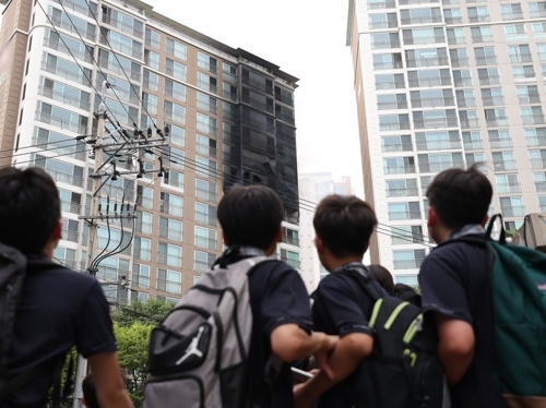 20일 오후 서울 강남구 역삼동 한 아파트 10층에서 화재가 발생해 인근 하교하던 학생들이 화재현장을 지켜보고 있다. 연합뉴스