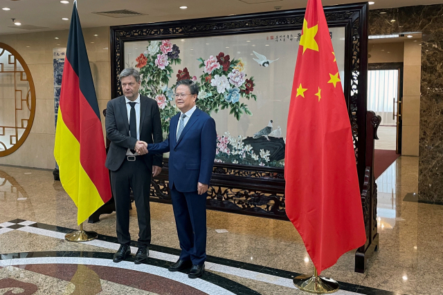 로베르트 하베크 독일 부총리 겸 경제기후보호부 장관이 22일 중국 베이징에서 열린 고위급 회담에 앞서 정산제 국가발전개혁위원회 주임과 악수를 하고 있다. 로이터연합