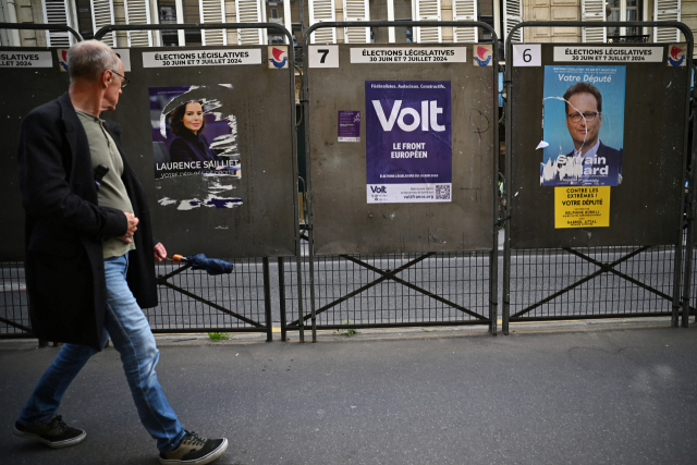프랑스 총선을 앞두고 있는 22일 한 시민이 파리에 있는 투표소 앞을 걷고 있다. 로이터연합뉴스