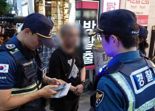 지난 25일 오후 제주시 제원사거리 인근 도로에서 무단횡단한 외국인 관광객에게 경찰이 범칙금을 부과하고 있다. 연합뉴스