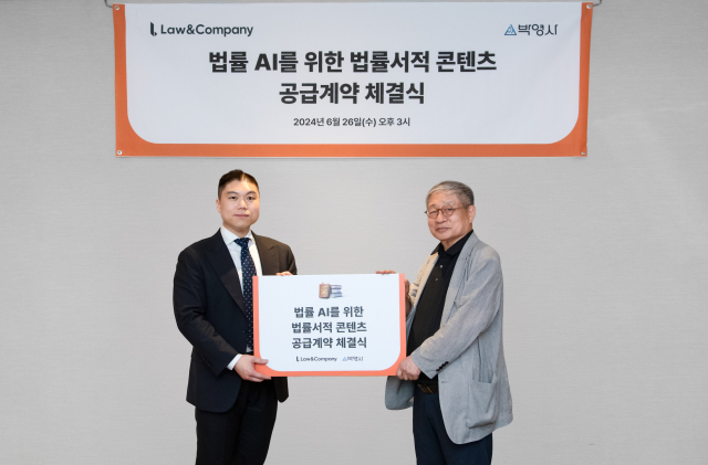 김본환(왼쪽) 로앤컴퍼니 대표와 안종만 박영사 회장이 26일 열린 ‘법률 AI를 위한 법률서적 콘텐츠 공급계약 체결식’에서 기념 사진을 촬영하고 있다. 사진제공=로앤컴퍼니