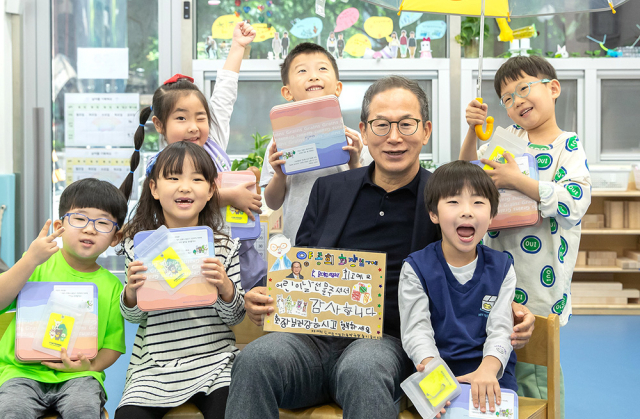 양종희(앞줄 왼쪽 세 번째) KB금융그룹 회장이 서울 ‘KB여의도직장어린이집’을 찾아 어린이들에게 선물을 건네고 함께 기념 촬영을 하고 있다. 사진 제공=KB금융