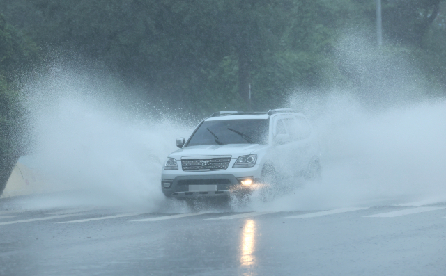 제주도에 호우특보가 내려진 지난 20일 제주 서귀포시 중문의 한 도로에 빗물이 고여 차량이 물보라를 일으키며 지나고 있다. 연합뉴스