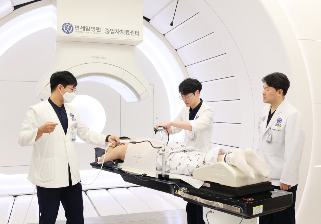 금웅섭(오른쪽) 연세암병원 중입자치료센터장과 의료진이 정확한 치료를 위해 장비를 조정하고 있다. 사진 제공=연세암병원