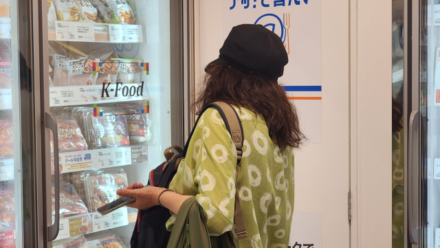 일본 도쿄의 한 대형 유통매장 이온몰에서 소비자가 마트 내 K-푸드 냉동식품 코너에서 상품을 살피고 있다. 도쿄=조윤진 기자