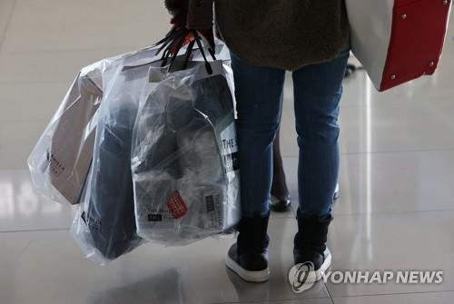 비닐에 담긴 면세품을 들고 가는 여행객. 연합뉴스