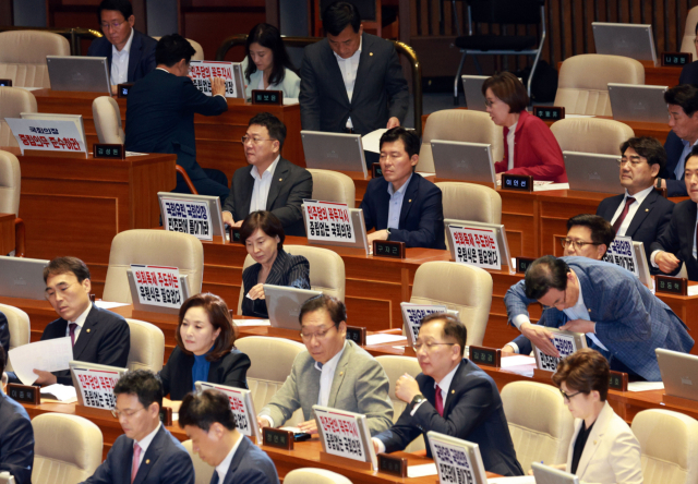 2일 국회에서 열린 본회의에서 국민의힘 의원들이 입장하며 자리에 피켓을 붙이고 있다. 연합뉴스