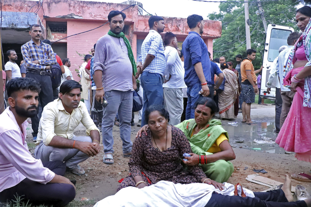 2일(현지시간) 인도 북부의 한 병원 밖에서 유족들이 망연자실한 얼굴로 가족의 시신을 보고있다. 이날 수천 명이 모인 종교 집회에서 압사로 최소 107명이 사망했다. AP연합뉴스