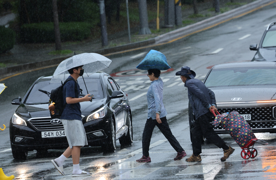 광주와 전남 일부지역에 호우주의보가 발효된 29일 광주 서구 화정동 한 거리에서 시민들이 빗길을 걸어가고 있다. 뉴스1