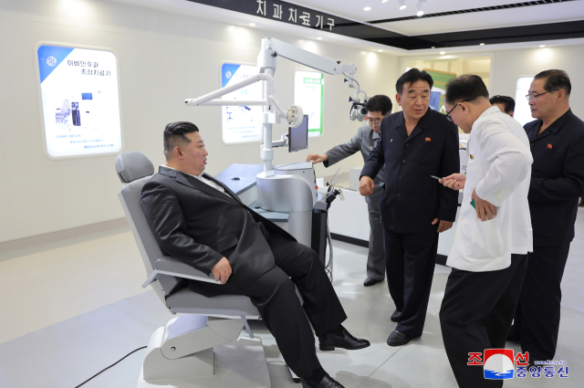 김정은(왼쪽) 북한 국무위원장이 2일 당 간부들과 의료기구 생산 공장을 찾아 의료용 의자에 앉아보고 있다. 연합뉴스