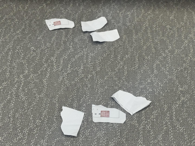 2일 최저임금위원회 7차 전원회의가 열린 최저임금위 회의장 바닥에 근로자위원들이 찢은 투표용지가 떨어져 있다. 연합뉴스