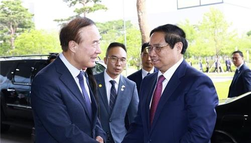 전영현(왼쪽) 삼성전자 디바이스솔루션(DS) 부문장이 3일 경기 평택시 삼성전자 반도체 공장을 방문한 팜 민 찐 베트남 총리를 맞이하고 있다.베트남 TTXVN 캡처
