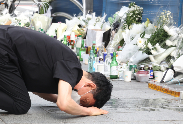 4일 오전 서울 중구 시청역 인근 역주행 사고 현장에서 한 추모객이 절을 하고 있다. 지난 1일 해당 교차로에서는 운전자 A씨가 몰던 승용차가 역주행하며 인도로 돌진해 9명이 사망했다. 연합뉴스