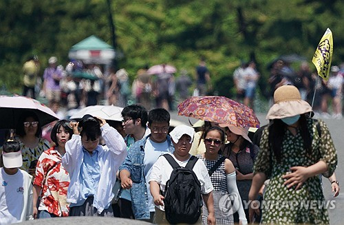 일본 도쿄 도심 최고기온이 35.5도까지 오른 5일 여행자들이 도쿄 도심 정원에서 걸어가고 있다. AFP 연합뉴스