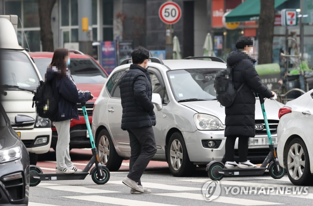 서울 회기역 인근에서 시민들이 전동킥보드를 탄 채 횡단보도를 건너고 있다. 연합뉴스