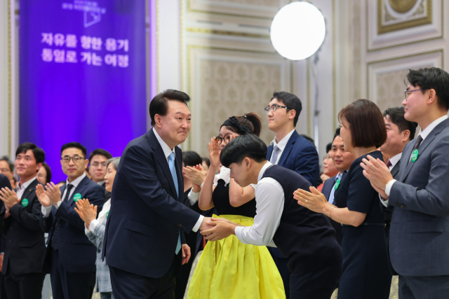 윤석열 대통령이 14일 청와대 영빈관에서 열린 '제1회 북한이탈주민의날 기념식'에 입장하며 참석자들과 인사하고 있다. 연합뉴스