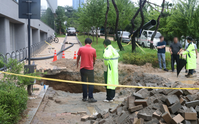 16일 세종시 한 아파트 인근 산책로에서 싱크홀이 발생해 관계 기관이 긴급 복구를 하고 있다. 연합뉴스