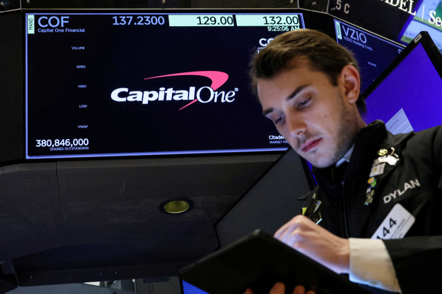 FILE PHOTO: A screen displays the logo and trading information for Capital One Financial as a trader works on the floor at the New York Stock Exchange in New York City, U.S., February 20, 2024. REUTERS/Brendan McDermid/File Photo