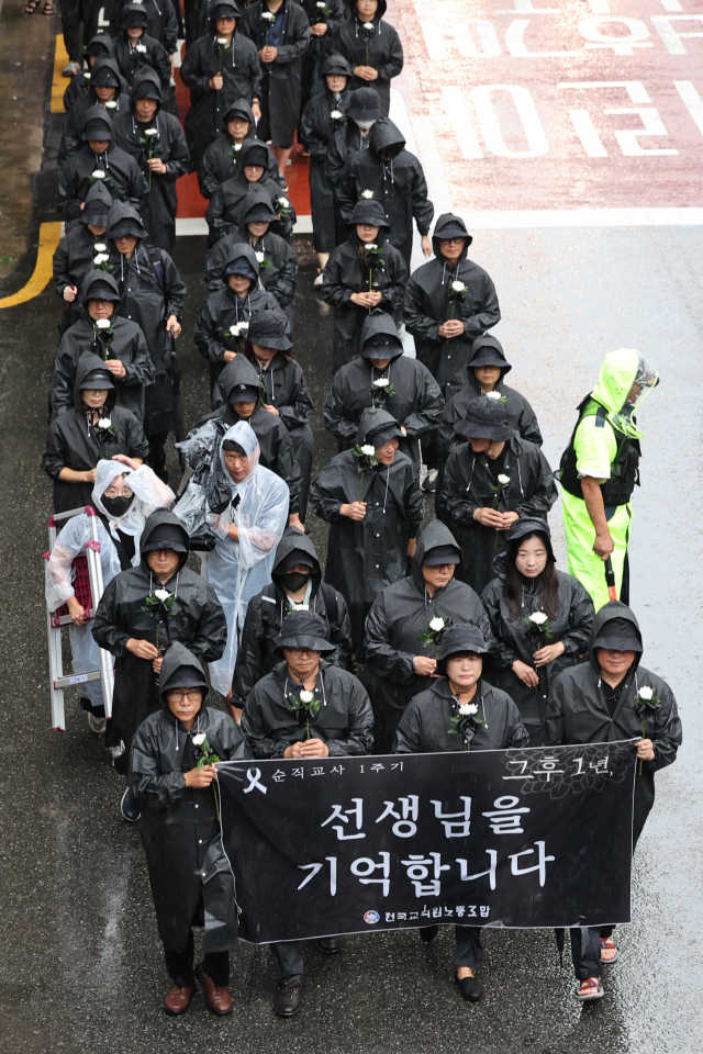 서이초등학교 교사 사망 1주기인 18일 오전 서울 서초구 서이초교교차로에서 출발한 교사유가족협의회 관계자와 전국교직원노동조합 조합원들이 서초경찰서 방향으로 고인을 추모하며 행진하고 있다. 연합뉴스