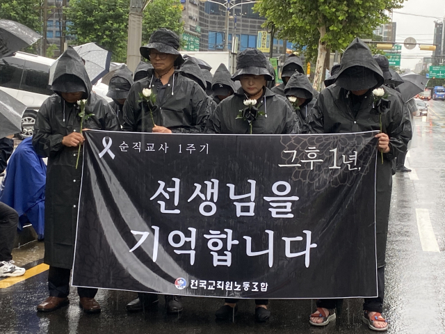 18일 서울 서초구 일대에서 열린 서이초 순직 교사 1주기 추모 걷기 행사에 참석한 교사들이 묵념을 하고 있다. 이승령 기자