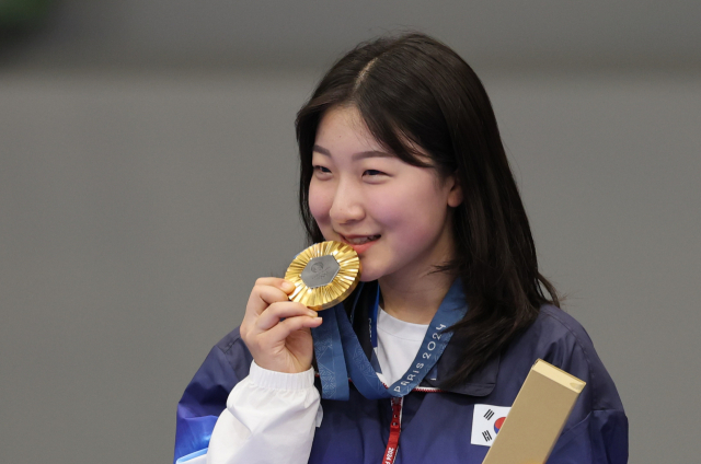 반효진이 29일(한국 시간) 프랑스 샤토루슈팅센터에서 열린 파리 올림픽 사격 공기소총 10ｍ 여자 결선에서 우승한 뒤 금메달을 입에 대고 있다. 샤토루=성형주 기자