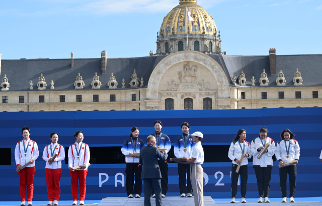 28일(현지시간) 프랑스 파리 앵발리드 경기장에서 열린 2024파리올림픽 양궁 여자 리커브 단체 결승 한국과 중국의 경기에서 금메달을 획득한 한국 전훈영, 임시현, 남수현이 시상식에서 정의선 현대자동차그룹 회장으로부터 선물을 전달받고 있다. 파리=성형주 기자