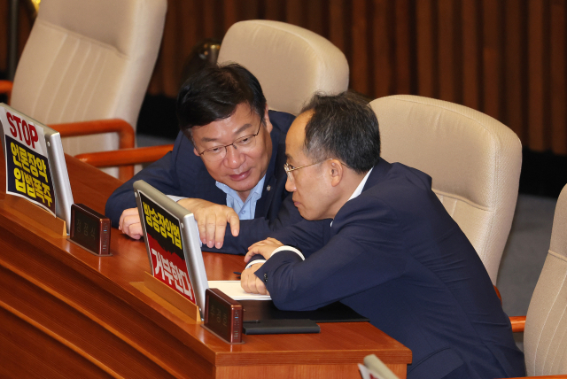 추경호(오른쪽) 국민의힘 원내대표와 정점식 정책위의장이 30일 오전 같은 당 정성국 의원의 필리버스터가 진행 중인 국회 본회의장에서 대화하고 있다. 연합뉴스