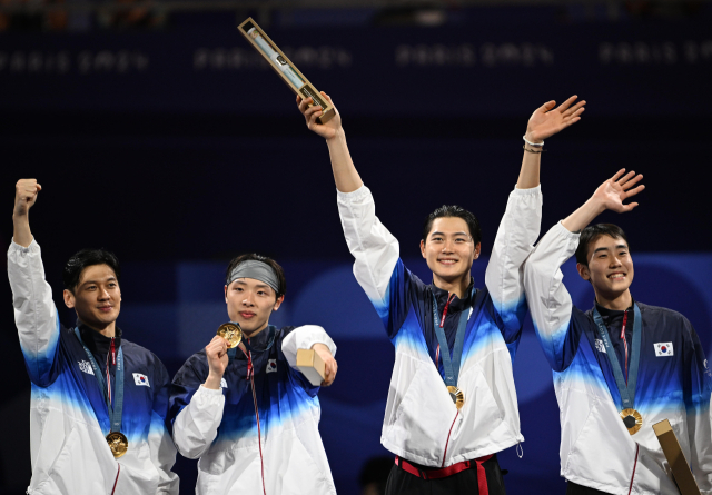 한국 펜싱 남자 사브르 대표팀의 구본길(왼쪽부터)·박상원·오상욱·도경동이 1일 파리 올림픽 단체전에서 우승한 뒤 시상식에서 관중 환호에 화답하고 있다. 파리=성형주 기자