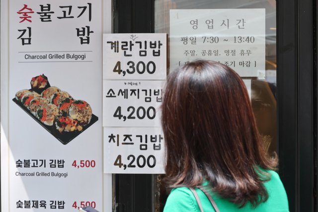 한 시민이 4일 오후 서울 종로구 관철동 식당가에서 김밥 가격을 보고 있다. 연합뉴스.