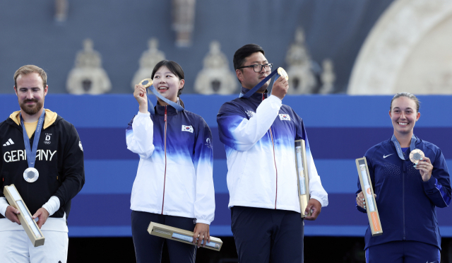 김우진과 임시현이 2일(현지 시간) 프랑스 파리 앵발리드에서 열린 2024 파리 올림픽 양궁 혼성 단체 결승에서 금메달을 획득한 뒤 시상대에서 메달을 들어보이고 있다. 파리=성형주 기자