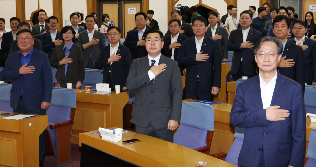 박찬대(가운데) 더불어민주당 대표 직무대행 겸 원내대표와 의원들이 6일 국회 의원회관에서 열린 ‘경제는 민주당’ 출범 및 특강에서 국기에 경례하고 있다. 연합뉴스