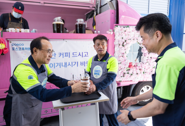 유병옥(왼쪽) 포스코퓨처엠 사장이 7일 포항 블루밸리산업단지 인조흑연 음극재 공장을 찾아 직원에게 아이스 커피를 전달하고 있다. 사진 제공=포스코퓨처엠