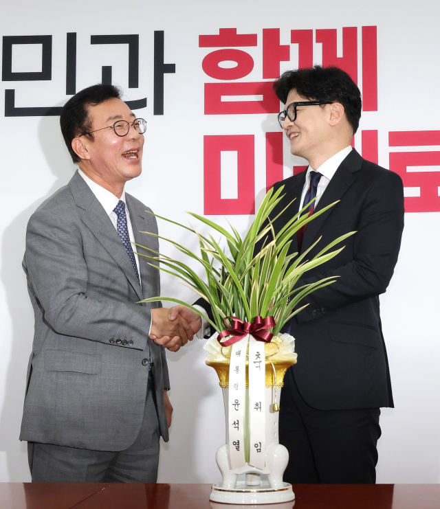 국민의힘 한동훈 신임 대표가 24일 오후 윤석열 대통령의 축하 난을 가지고 국회를 예방한 홍철호 대통령실 정무수석(왼쪽)을 맞이하고 있다.연합뉴스