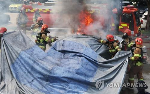 질식소화덮개를 활용한 전기차 화재 진압 시연. 연합뉴스