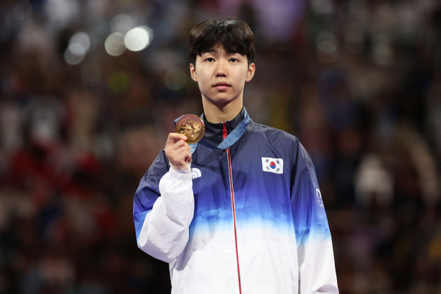 7일(현지시간) 프랑스 파리 그랑팔레 태권도경기장에서 열린 2024 파리올림픽 태권도 남자 58kg급 결승전에서 한국 박태준이 아제르바이잔의 가심 마고메도프에게 승리해 금메달을 따낸 뒤 가진 시상식에서 메달을 들어보이고 있다. 연합뉴스