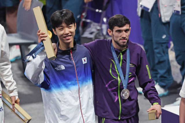 7일(현지시간) 프랑스 파리 그랑팔레 태권도경기장에서 열린 2024 파리올림픽 태권도 남자 58kg급 시상식을 마친 금메달을 차지한 한국 박태준이 부상 기권으로 은메달을 차지한 아제르바이잔 가심 마고메도프를 부축하고 있다.연합뉴스