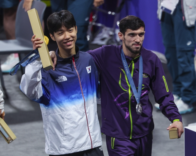 7일(현지시간) 프랑스 파리 그랑팔레 태권도경기장에서 열린 2024 파리올림픽 태권도 남자 58kg급 결승전에서 금메달을 목에 건 박태준이 이어진 시상식에서 부상을 입은 마고메도프를 어깨 동무해 부축하며 행사장을 떠나고 있다. 연합뉴스