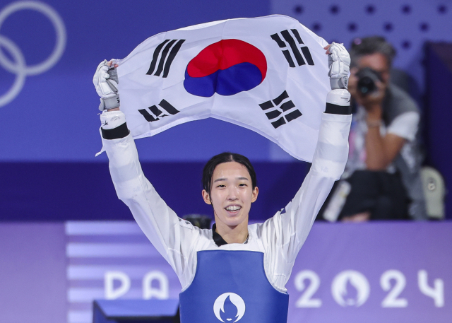 8일(현지시간) 프랑스 파리 그랑팔레 태권도경기장에서 열린 2024 파리올림픽 태권도 여자 57kg급 결승에서 한국의 김유진이 이란의 나히드 키야니찬데를 꺾고 금메달을 확정한 뒤 태극기를 들고 환호하고 있다. 연합뉴스