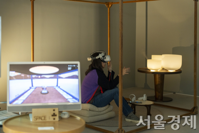 아트코리아랩 6층 쇼룸에서 관람객이 가상현실(VR) 기기를 쓰고 메타버스 공간에서 명상을 즐기고 있다. 감상하고 있는 작품은 아트코리아랩에 입주해 있는 프로젝트 팀 ‘스페이스몸’이 메타버스 기술을 활용해 만든 몰입형 예술명상 플랫폼 ‘고요행성’이다. 사진 제공=예경