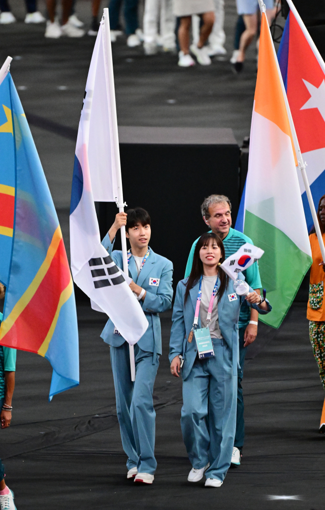 12일(한국 시간) 파리 올림픽 폐막식에서 태권도 박태준(왼쪽)과 복싱 임애지가 태극기를 들고 입장하고 있다. 생드니=성형주 기자