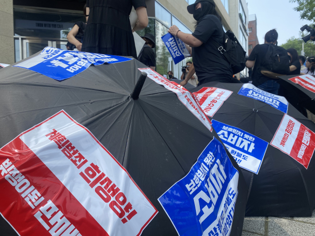 13일 서울 강남구 신사동 티몬 사옥 앞에서 열린 피해자 집회에 티메프를 규탄하는 문구가 부착된 검은 우산이 놓여있다. 이승령 기자