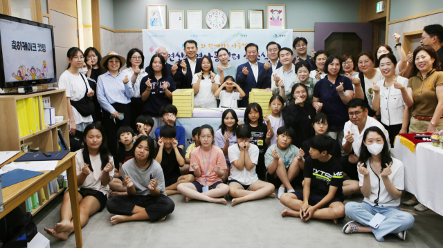 정은보(현수막 기준 좌측) 한국거래소 이사장이 부산 연제구 'KRX지역아동센터' 개소식 후 지역아동센터 아동 및 관계자들과 기념 촬영을 하고 있다.