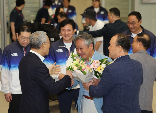 이기흥(앞줄 왼쪽 두번째)대한체육회장이 13일 오후 인천국제공항 제2여객터미널을 통해 귀국해 유인촌(앞줄 왼쪽) 문화체육관광부 장관과 인사를 나누고 있다. 연합뉴스