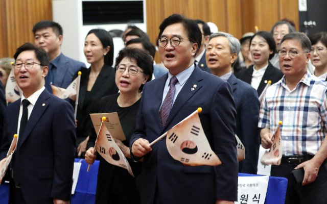 우원식 국회의장이 14일 오전 대전국립현충원에서 열린 광복 79주년 및 홍범도 장군 귀환 3주년 기념식에 참석하여 봉오동 전투에서 사용했던 태극기를 흔들며 '날으는 홍범도 장군가'를 제창하고 있다. 뉴스1